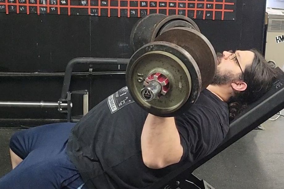 Man performing incline bench with TItan Loadable Dumbbells